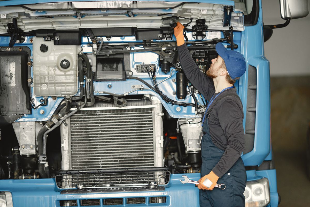 Stock photograph of a mechanic inspecting a truck engine
